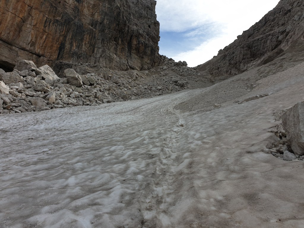 Canalone di sassi, ghiaia e neve sotto la Bocca di Brenta visto dal basso